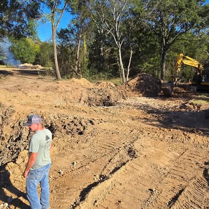 Land clearing site with excavator and crew on site