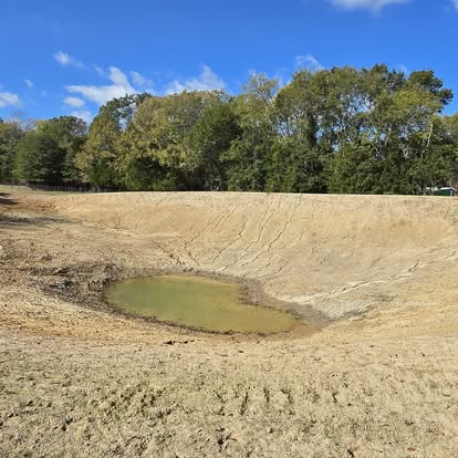 Newly excavated pond with water at center